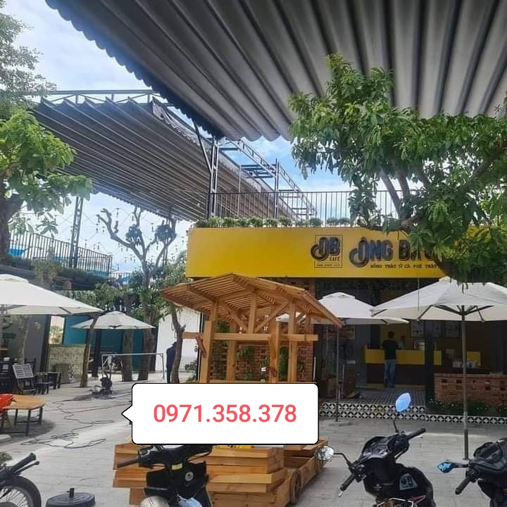 Mái xếp lượn sóng màu trắng tại quán cà phê, cung cấp che chắn ngoài trời hiệu quả