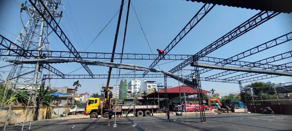 Kỹ thuật viên lên bạt mái che lượn sóng, sử dụng thiết bị hiện đại để đảm bảo chất lượng.